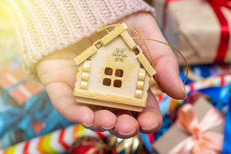 Hand holding house home Christmas tree decoration fur spruce Christmas toys. Holidays preparations...