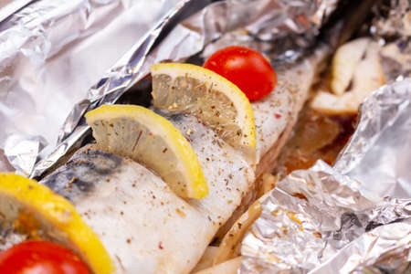 Raw mackerel on the foil with lemon and cherry tomatoes and spices healthy delicious tasty foodの写真素材
