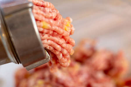 cooking minced meat with onions and crackers on a white meat grinder or mincer