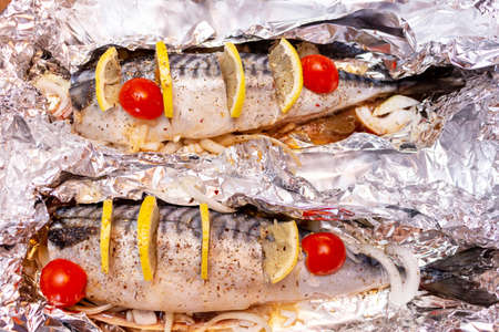 Raw mackerel on the foil with lemon and cherry tomatoes and spices healthy delicious tasty foodの写真素材