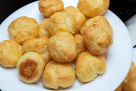 homemade profiteroles on a white plate close up