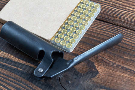 Shotgun shells reloading process with special reload equipment. Powder, bullets, fraction, shells, buckshot on the wooden background.の写真素材