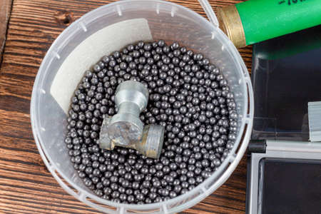 reloading process shotgun shells with special reload equipment. Powder, bullets, fraction, shells, buckshot on the wooden backgroundの写真素材