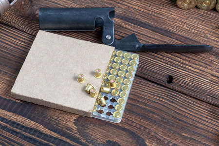 reloading process shotgun shells with special reload equipment. Powder, bullets, fraction, shells, buckshot on the wooden backgroundの写真素材