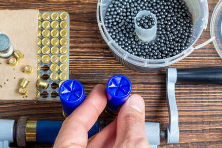 reloading process shotgun shells with special reload equipment. Powder, bullets, fraction, shells, buckshot on the wooden backgroundの写真素材