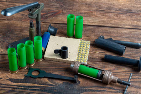 reloading process shotgun shells with special reload equipment. Powder, bullets, fraction, shells, buckshot on the wooden backgroundの写真素材