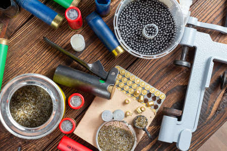 reloading process shotgun shells with special reload equipment. Powder, bullets, fraction, shells, buckshot on the wooden backgroundの写真素材