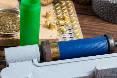 reloading process shotgun shells with special reload equipment. Powder, bullets, fraction, shells, buckshot on the wooden backgroundの写真素材
