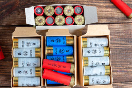 12 gauge caliber color cartridges hunting shells in a box pack on a brown wooden background