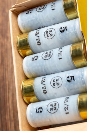 12 gauge caliber color cartridges hunting shells box pack on a brown wooden background