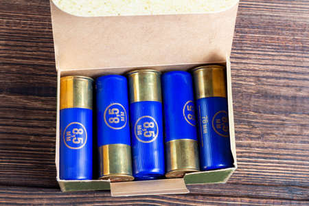 12 gauge caliber color cartridges hunting shells box pack on a brown wooden background
