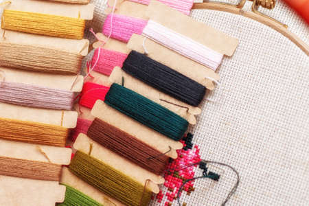 Cross stitching embroidery process. Needle embroidery frame threads. Hobby DIY lifestyle.