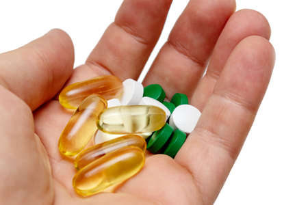 Vitamin e omega 3 fish oil yellow pills in a hand vitamins sport nutrition healthy on the white background isolated close upの写真素材