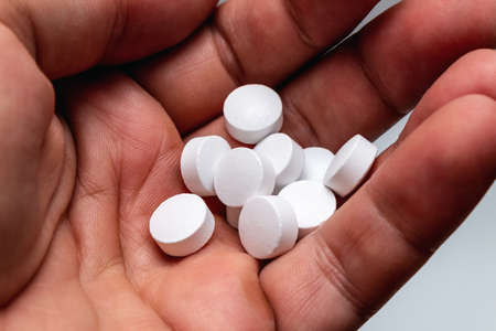 Vitamin white pills in a hand vitamins sport nutrition healthy on the white background isolated...