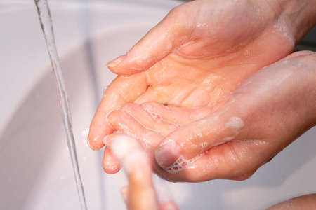 woman washes hands under the tap close up