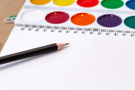composition with notebook blank page colorful pencil, marker and pen mock-up Back to school concept with stationery office supplies on a craft cardboard backgroundの写真素材