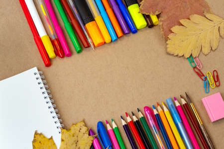 composition with notebook blank page colorful pencil, marker and pen mock-up Back to school concept with stationery office supplies on a craft cardboard backgroundの写真素材