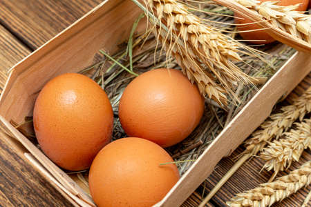 farm brown eggs with straw in birch bark box wooden background close-up
