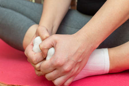 woman doing yoga stretching at home close upの写真素材