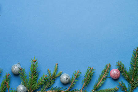 Christmas tree toys, green fir, spruce branches on blue background