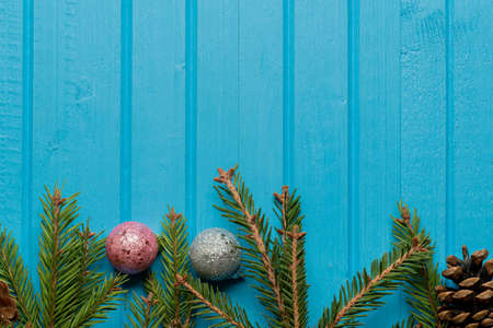 Fir, spruce branches and Christmas tree toys on blue wooden background with copy spaceの写真素材