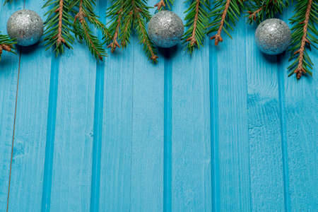 Fir, spruce branches and Christmas tree toys on blue wooden background with copy spaceの写真素材