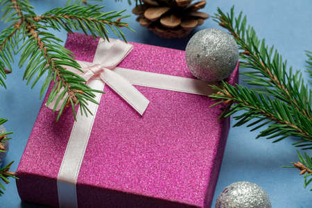 Gift box with Christmas tree toys, green fir, spruce branches