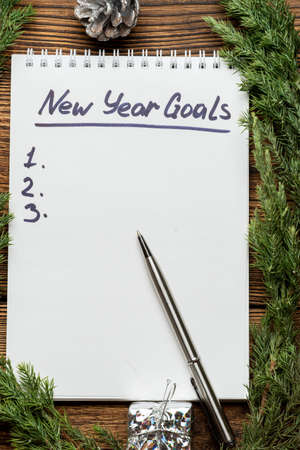new year goals inscription in notebook with fir, spruce branches and Christmas tree toys