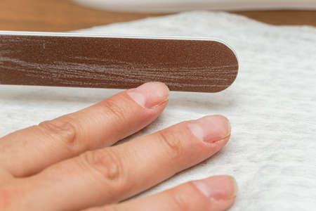 Nail polishing with file during manicure close up