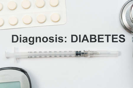Diabetes diagnosis word with syringe, pills, blood sugar test and stethoscopeの写真素材