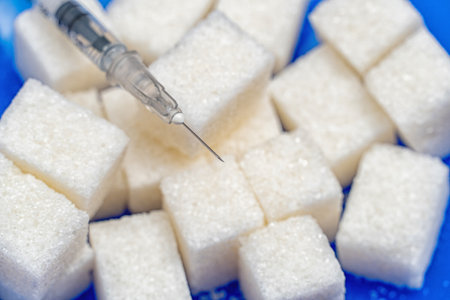 Heap of sugar and syringe on blue background. Testing, treatment diabetes conceptの写真素材