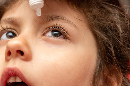 treatment, using therapeutic, medical eye drops for a child with conjunctivitisの写真素材