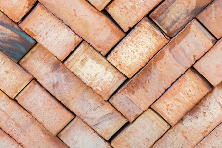 Lot of red ceramic bricks backdrop at construction, building siteの写真素材