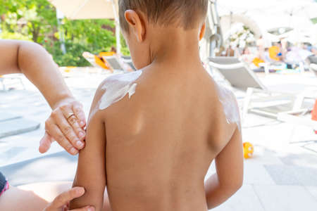 Applying sunscreen cream to the face of a small child, sun and ultraviolet protectionの写真素材