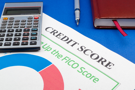 Credit score report with keyboard and notepad on a blue table.の写真素材