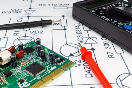 Multimeter probes examining the computer Board on the background of the circuit.の写真素材