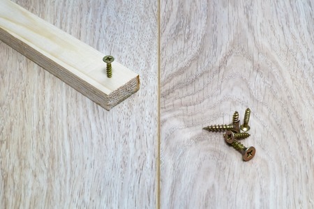 Screws and wooden bar on the table close-up.の写真素材