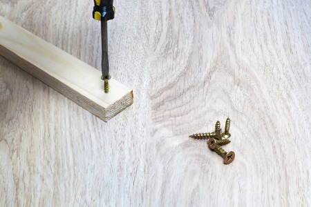Hammer to hammer a nail into a wooden bar close-up.の写真素材