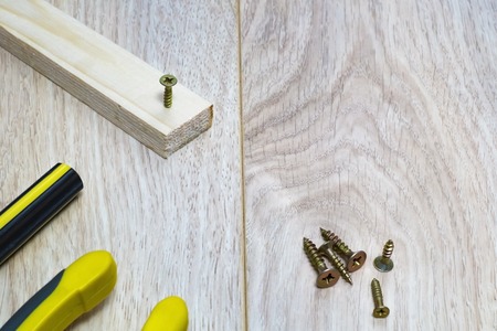 Hammer to hammer a nail into a wooden bar close-up.