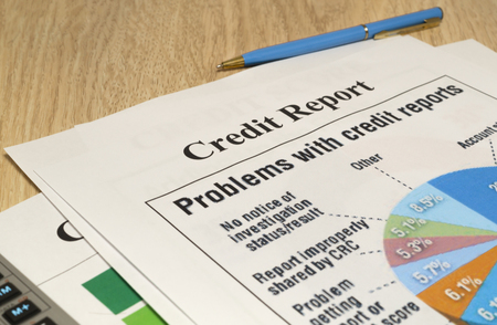 Credit report chart with pen and calculator on wooden table close-up.の写真素材