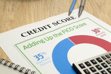 Credit score report with calculator, notebook and pen on a table.の写真素材