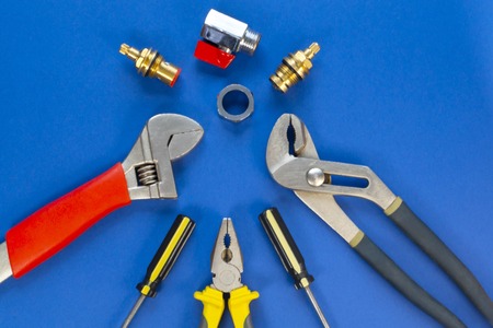 A set of tools for plumbing, isolated on a blue background with space for advertising.
