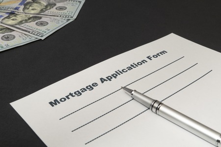 Empty form to fill mortgage with money and pen on black background close-up.の写真素材