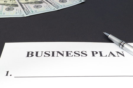 Strategy business plan with pen and money black on table close up.の写真素材