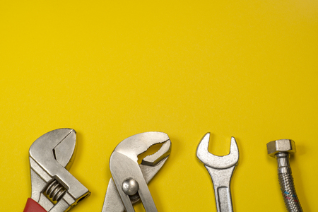 Necessary set of tools for plumbers on a yellow background with empty space for advertising.の写真素材