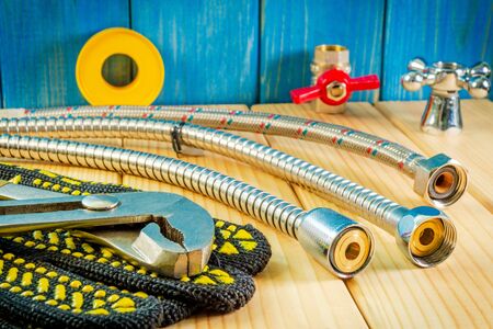 Hand tools for plumbing and parts on wooden background with space for advertising.. Set for locksmith or plumber.の写真素材