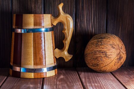 Wooden mug and coconut on dark wooden background. Beautiful still life. Beautiful still life in vintage colors.の写真素材
