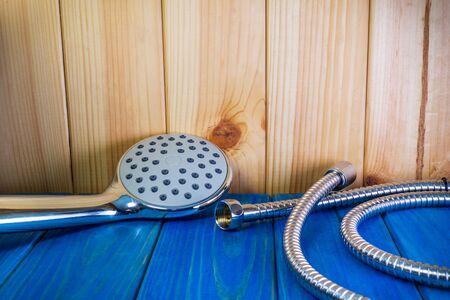 Shower head on blue wooden background and other plumbing parts close up.の写真素材