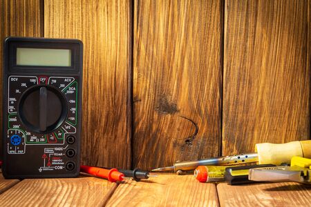 Electrical tester and a set of tools for electronics repair on vintage wooden background.の写真素材