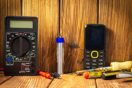 Electrical tester and a set of tools for electronics repair on vintage wooden background.の写真素材